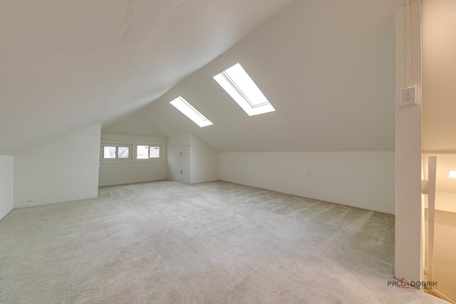 additional living space with carpet floors and lofted ceiling with skylight