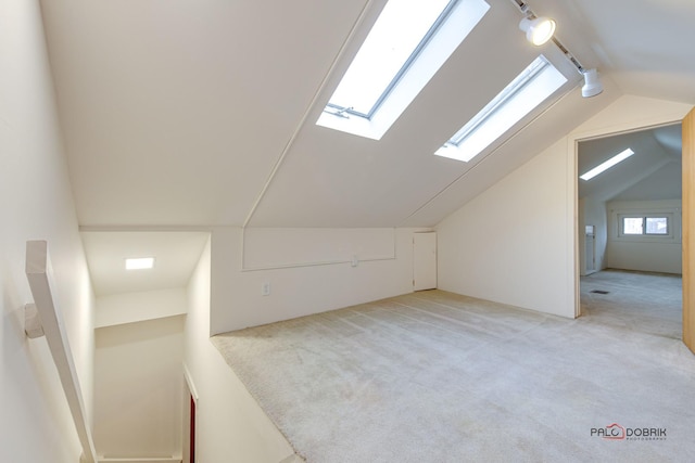 bonus room with light carpet and vaulted ceiling