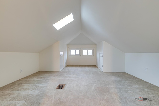 bonus room with lofted ceiling, visible vents, and light colored carpet