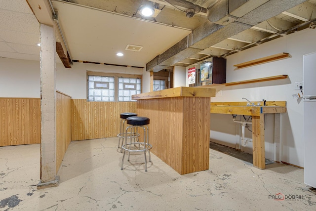 bar featuring a dry bar, wood walls, wainscoting, and visible vents