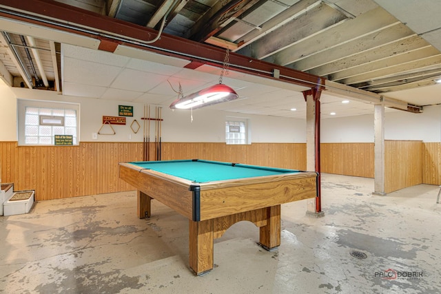 game room featuring concrete floors, wainscoting, and wooden walls