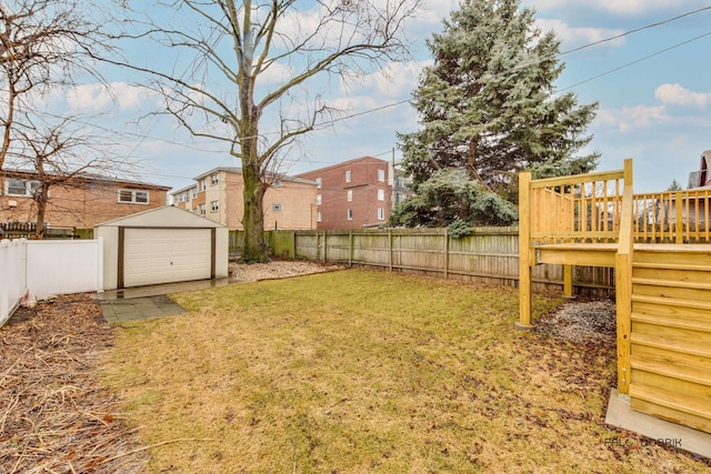 view of yard with a fenced backyard, an outdoor structure, a detached garage, and a shed