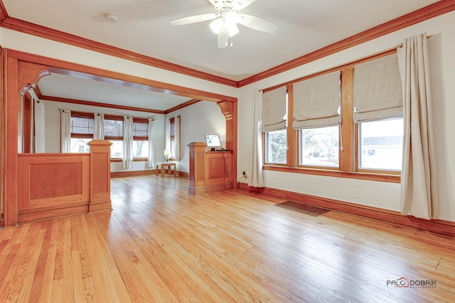 unfurnished living room featuring visible vents, baseboards, a ceiling fan, light wood-type flooring, and crown molding