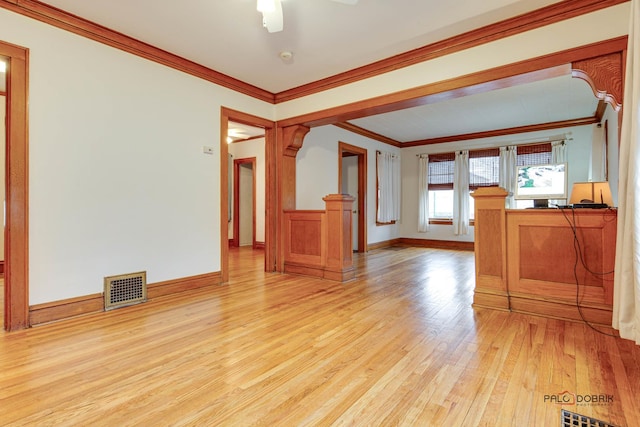 unfurnished living room featuring ornamental molding, light wood-type flooring, visible vents, and baseboards