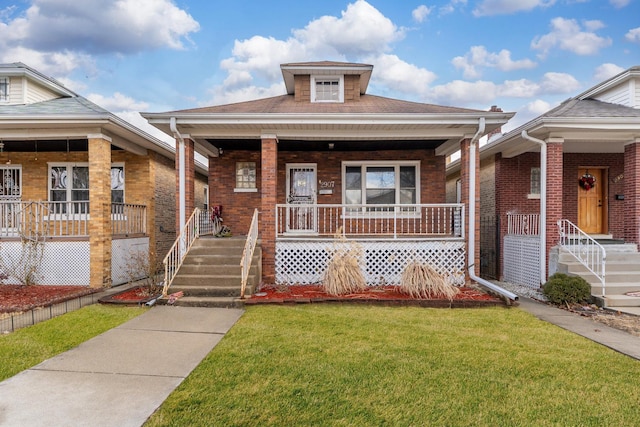 bungalow-style home with a porch, brick siding, and a front lawn