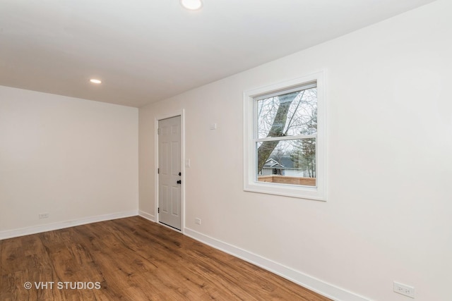 spare room with recessed lighting, baseboards, and wood finished floors