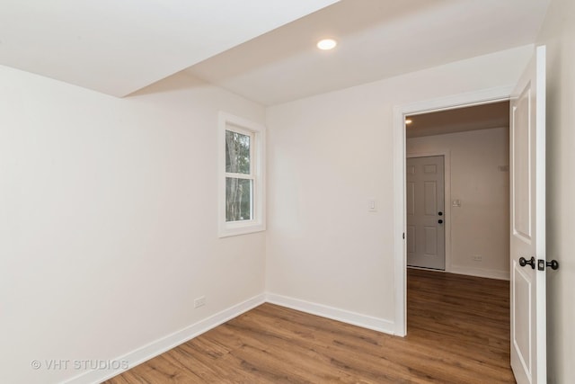 spare room with recessed lighting, baseboards, and wood finished floors