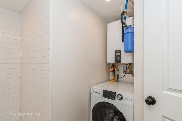 laundry room featuring laundry area, washer / clothes dryer, and tankless water heater