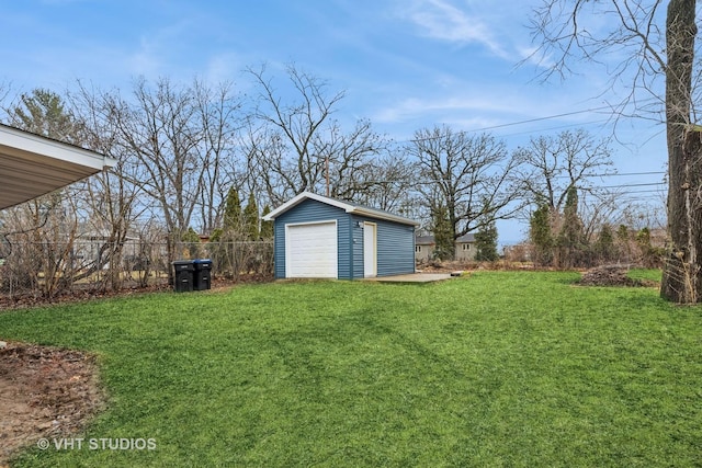 view of yard featuring an outbuilding, fence, and a garage