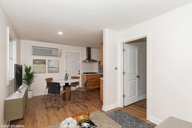 dining area with a wall mounted AC, recessed lighting, wood finished floors, and baseboards