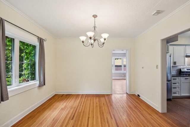 unfurnished room with light wood finished floors, a chandelier, baseboards, crown molding, and a smoke detector