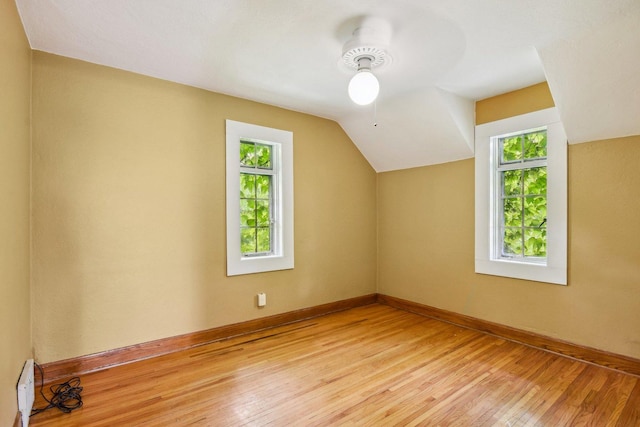 bonus room featuring healthy amount of natural light, light wood-style flooring, baseboards, a baseboard radiator, and lofted ceiling