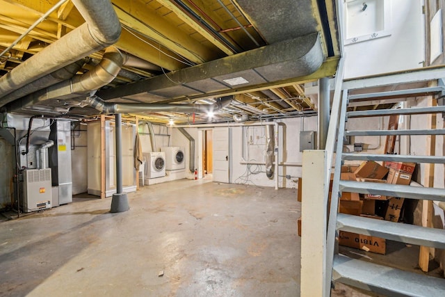 unfinished below grade area with washing machine and clothes dryer, heating unit, and electric panel