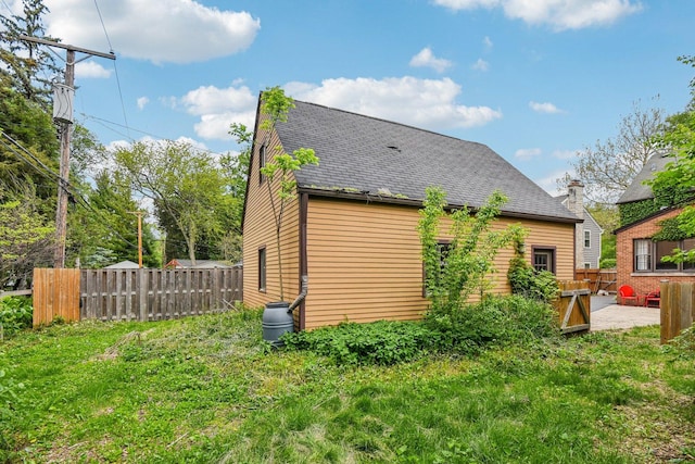 back of house featuring a patio, fence, and roof with shingles