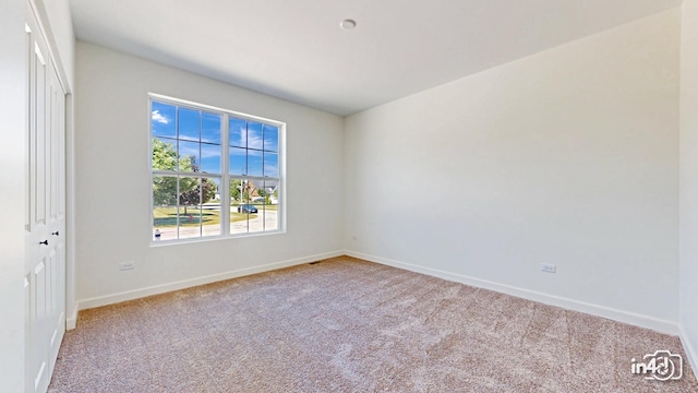 spare room with carpet and baseboards