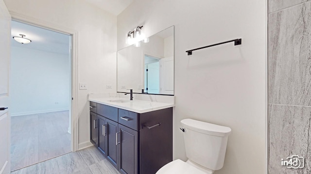 bathroom with vanity, toilet, and baseboards