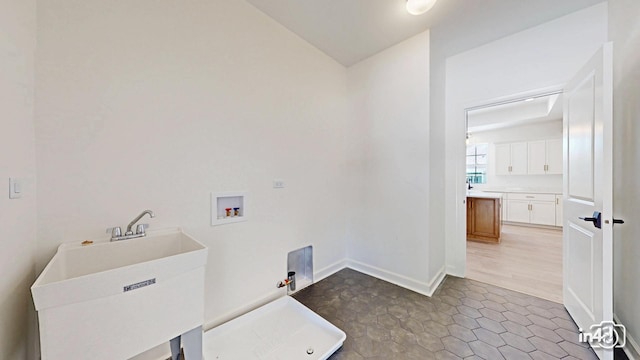 clothes washing area featuring laundry area, baseboards, hookup for a gas dryer, hookup for a washing machine, and a sink