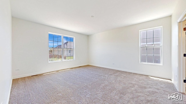 carpeted empty room featuring baseboards