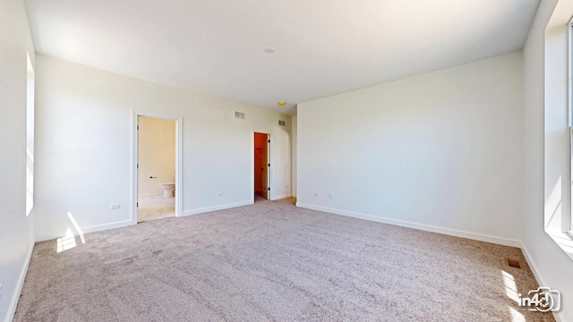 spare room featuring carpet, visible vents, and baseboards