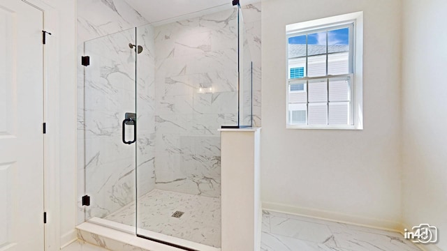 bathroom with marble finish floor, a marble finish shower, and baseboards