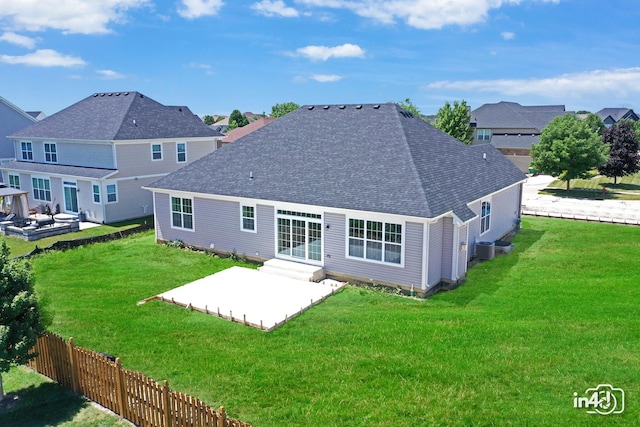 back of property featuring a patio area, roof with shingles, fence, and a yard