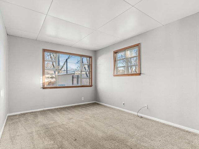 carpeted spare room featuring baseboards