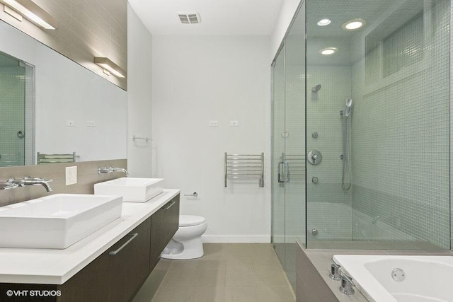 bathroom featuring toilet, a stall shower, visible vents, and a sink