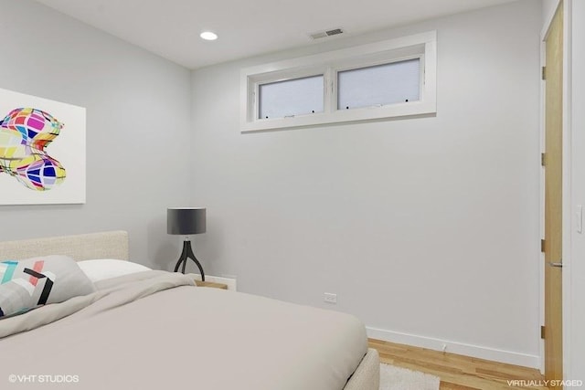 bedroom with recessed lighting, wood finished floors, visible vents, and baseboards