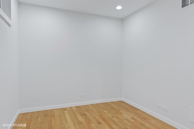 unfurnished room with light wood-type flooring, visible vents, and baseboards