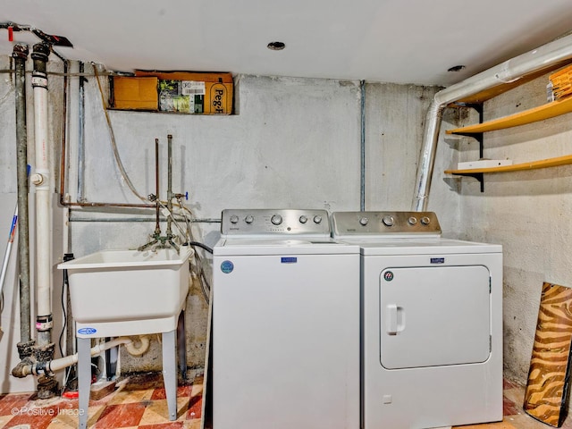 clothes washing area featuring laundry area, washer and clothes dryer, and a sink