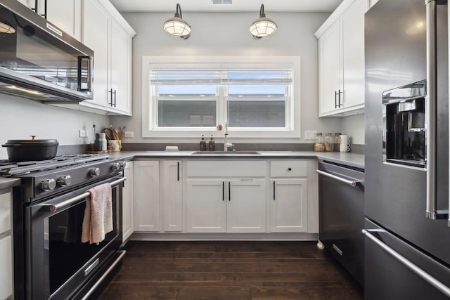 kitchen with white cabinets, dark wood-type flooring, stainless steel appliances, and a sink