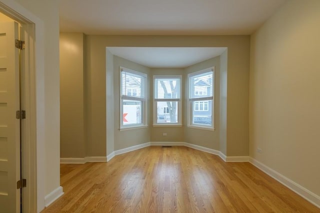 unfurnished room with light wood finished floors and baseboards