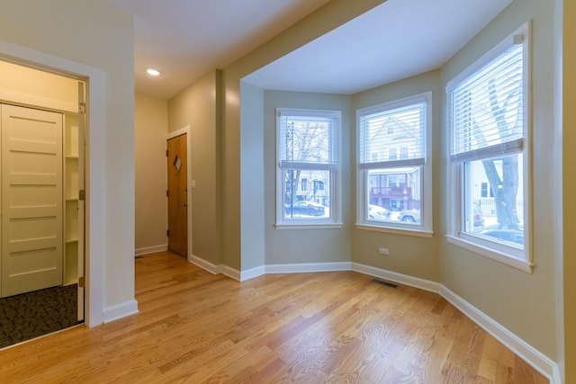 interior space featuring light wood-type flooring, a wealth of natural light, and baseboards