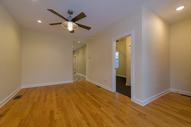 empty room with light wood-type flooring, visible vents, and baseboards