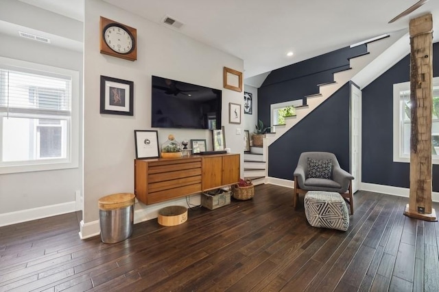 living area featuring stairs, baseboards, and wood finished floors