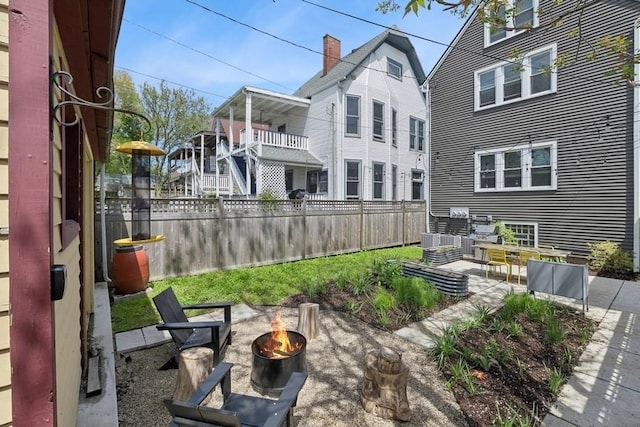 view of yard featuring a fire pit, a patio area, and fence