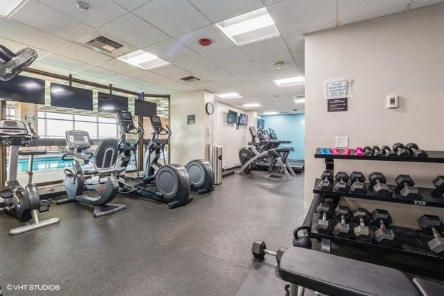 gym with a drop ceiling and visible vents