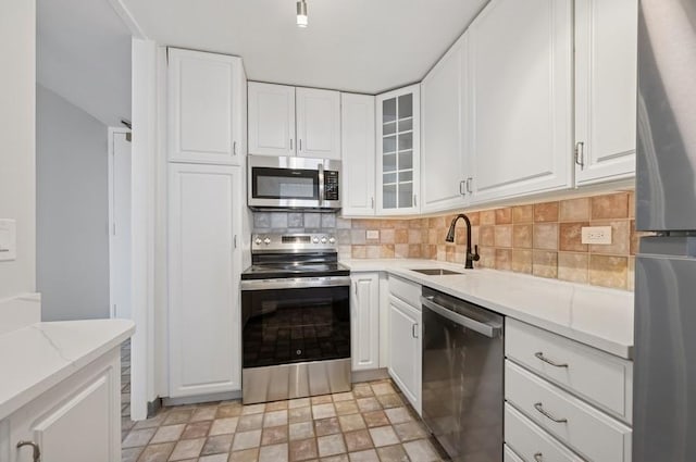 kitchen featuring appliances with stainless steel finishes, white cabinetry, and a sink