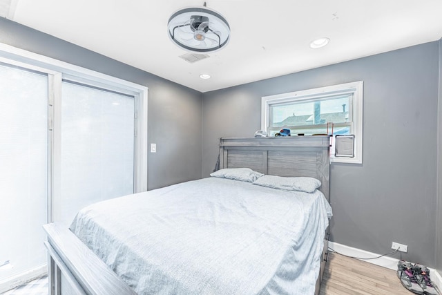 bedroom with light wood-style floors, recessed lighting, visible vents, and baseboards