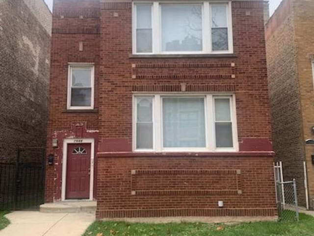 view of front of home with fence and brick siding