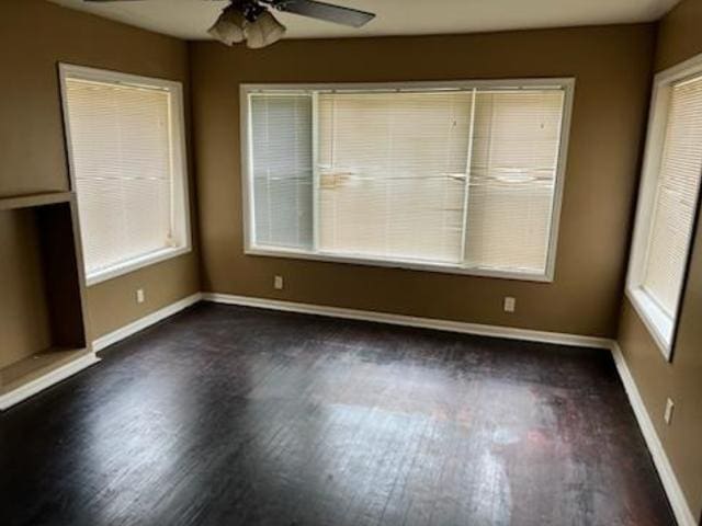 spare room with ceiling fan, baseboards, and wood finished floors