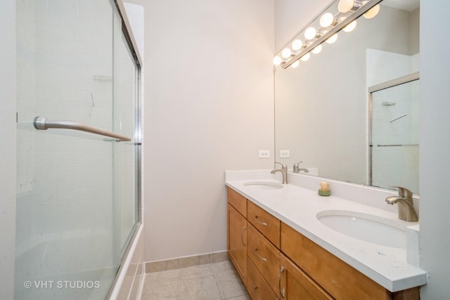 bathroom with tile patterned flooring, a shower with shower door, baseboards, and a sink