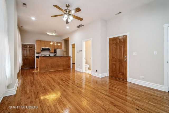 unfurnished living room with light wood-type flooring, visible vents, baseboards, and ceiling fan with notable chandelier