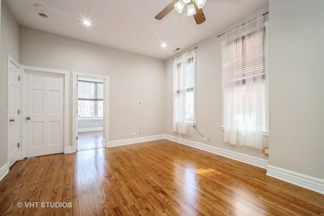 unfurnished room with visible vents, baseboards, recessed lighting, wood finished floors, and a ceiling fan