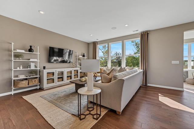 living area with a healthy amount of sunlight, hardwood / wood-style flooring, and baseboards