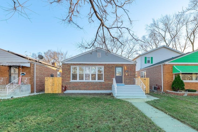 rear view of house with brick siding and a lawn