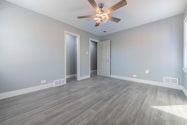 unfurnished bedroom featuring visible vents, baseboards, and wood finished floors