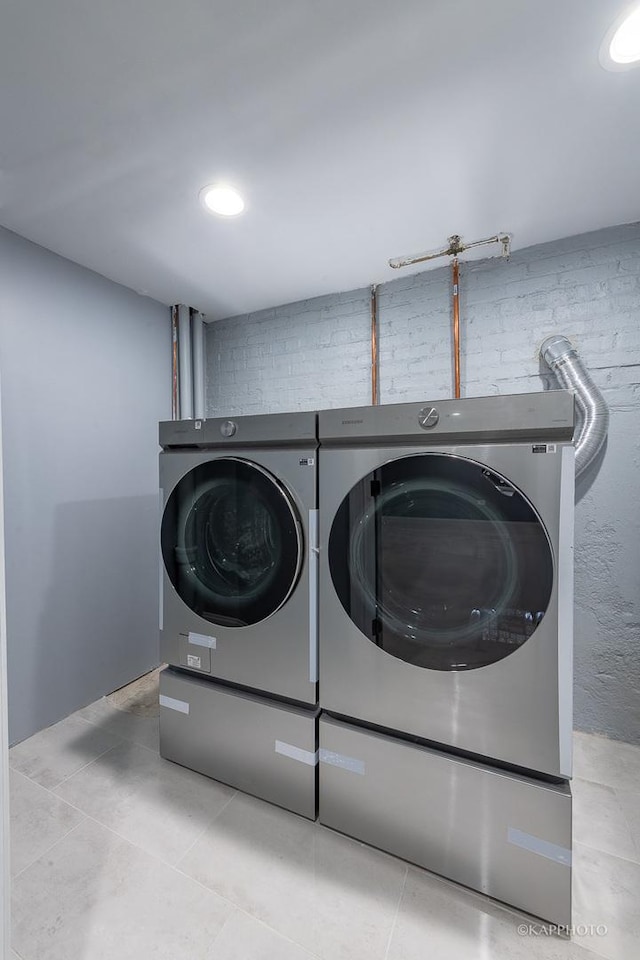 clothes washing area with laundry area, separate washer and dryer, and tile patterned flooring