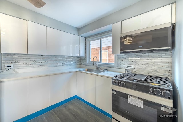 kitchen featuring tasteful backsplash, appliances with stainless steel finishes, light countertops, white cabinetry, and a sink