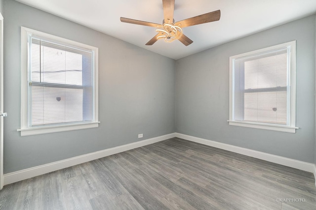 spare room with a ceiling fan, baseboards, and wood finished floors